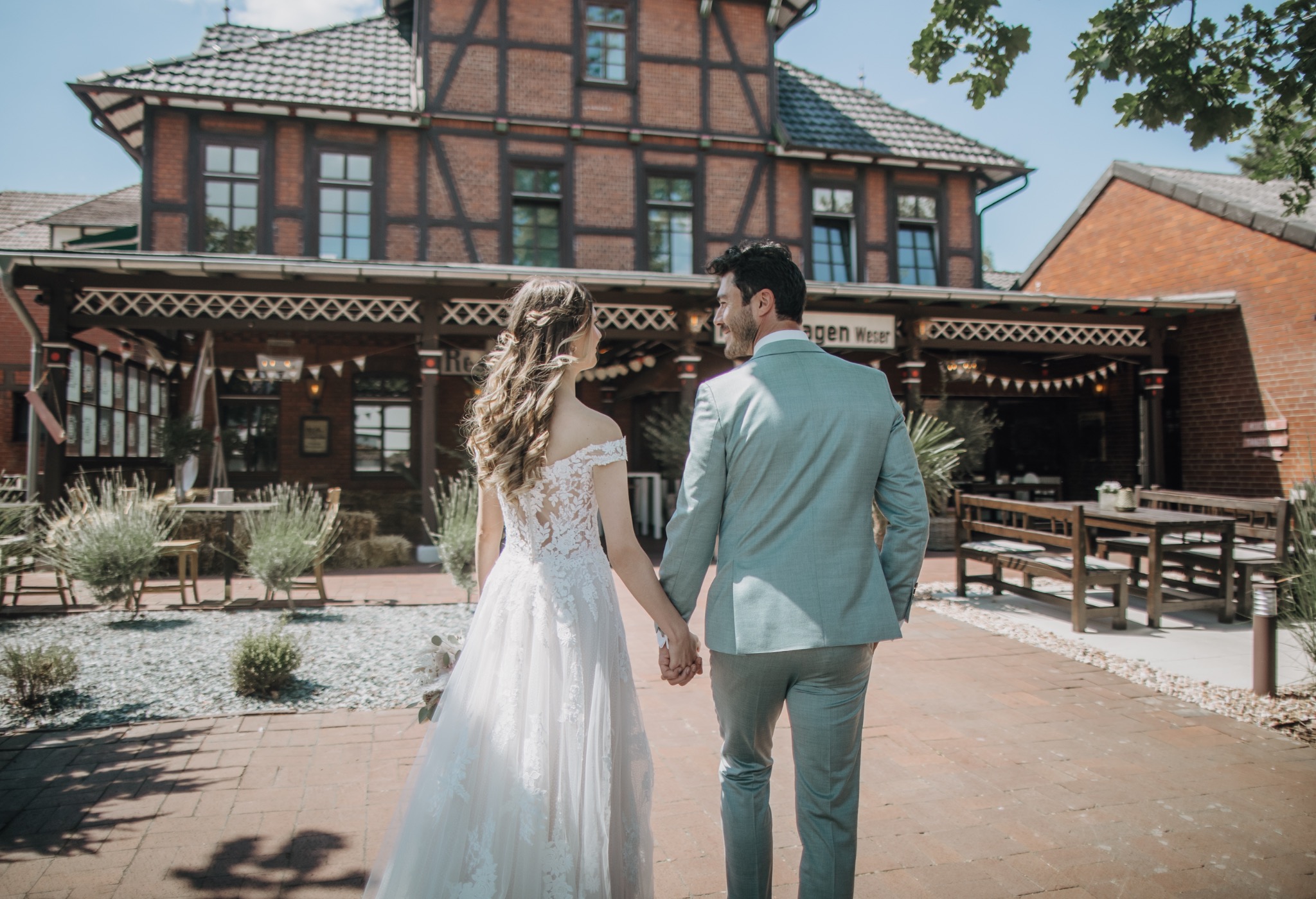 Hochzeitspaar geht Hand in Hand durch den Innenhof